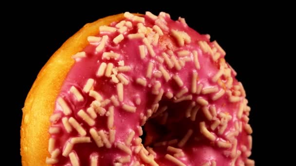 Roze Geglazuurde Donut Met Hagelslag Zwarte Achtergrond — Stockvideo