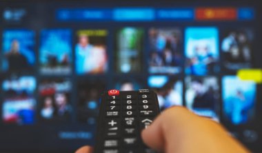 Akıllı TV 'yi gösteren uzaktan kumandalı bir erkek..