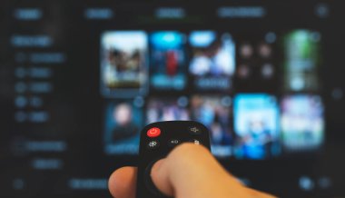 Akıllı TV 'yi gösteren uzaktan kumandalı bir erkek..