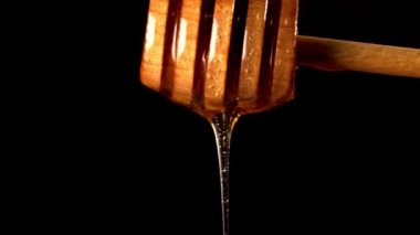 Siyah arka planda bal damlayan ahşap bal kaplaması..