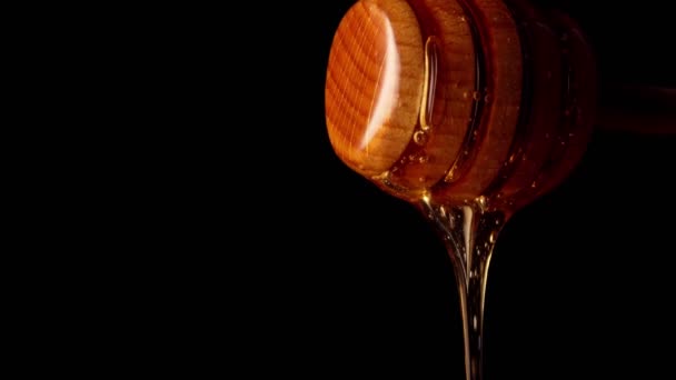 Honig Tropft Vom Hölzernen Honiglöffel Auf Schwarzem Hintergrund — Stockvideo
