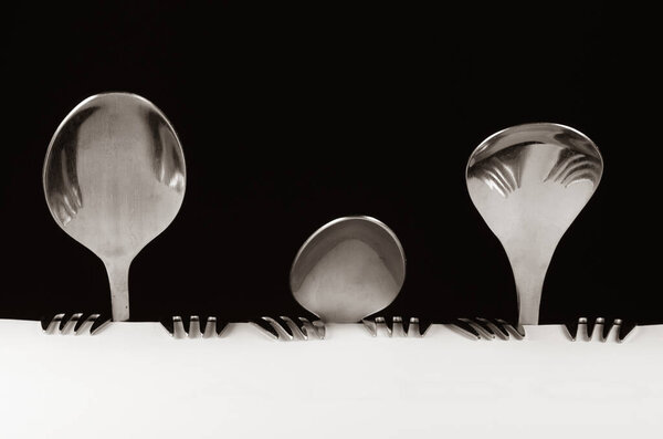 Abstract family made of spoon and forks sitting at the table.
