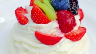 Tabağında çilek olan beyaz kremalı pasta.