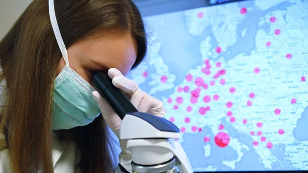 Scientist in medical mask in laboratory. On the background map with infections.