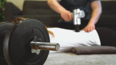 Masajcı kadının sırtına masaj aleti ile masaj yapıyor..