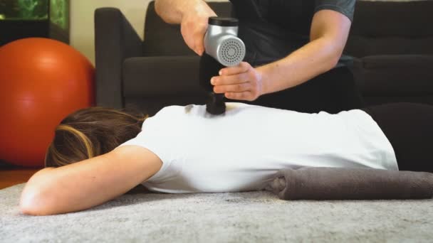 Terapista Massaggiare Schiena Della Donna Con Dispositivo Massaggio Percussione Casa — Video Stock