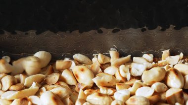 Kavrulmuş fıstıklar bıçakla ince ince doğranıyor..