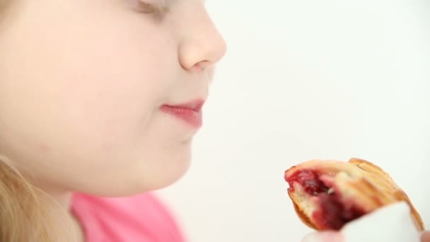 ブロンドの女の子がクローズ アップ ホワイト バック グラウンドの桜のパイを食べる — ストック動画