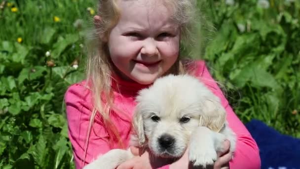 Beautiful little girl playing with a puppy in nature — Stock Video