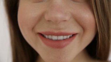 olumlu bir beyaz duvara poz güzel mutlu kız. portre çekimi, sığ derinlik-in tarla