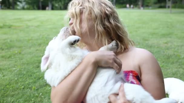 Jovem mulher brincando com filhotes de golden retriever no parque — Vídeo de Stock