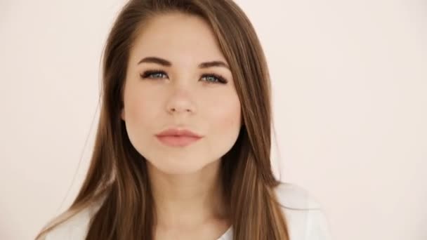 Bela menina de cabelos longos de aparência europeia com cabelos loiros olha para o seu rosto closeup — Vídeo de Stock