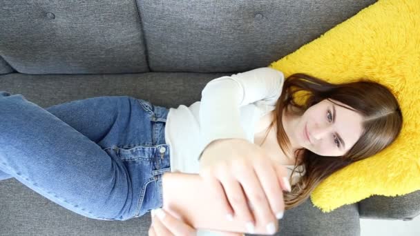 Schönes Mädchen macht Selfie auf dem Handy auf dem Sofa zu Hause — Stockvideo