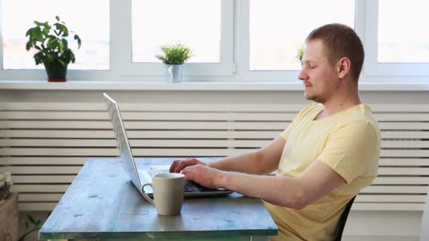 Man freelancer op afstand werkt thuis op laptop — Stockvideo