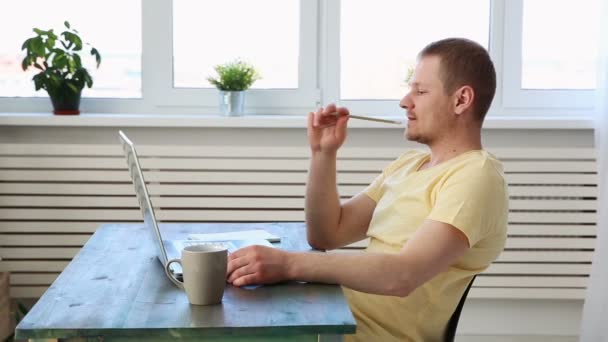 Hombre freelancer trabajando remotamente en casa en el portátil — Vídeo de stock