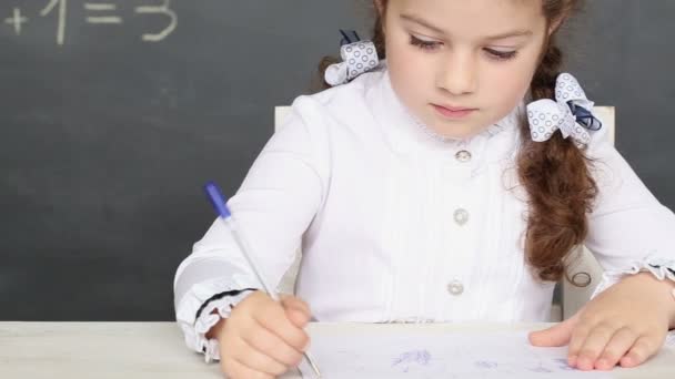 Mała dziewczynka siedzi przy biurku w szkole - shot śledzenia — Wideo stockowe