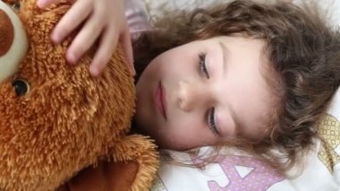 oyuncak ayı ile kanepede oturan küçük bir kız closeup, izleme vurdu