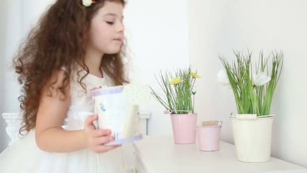 Niedliches kleines Mädchen, das die Blumen zu Hause aus der Gießkanne gießt - Kamerafahrt — Stockvideo