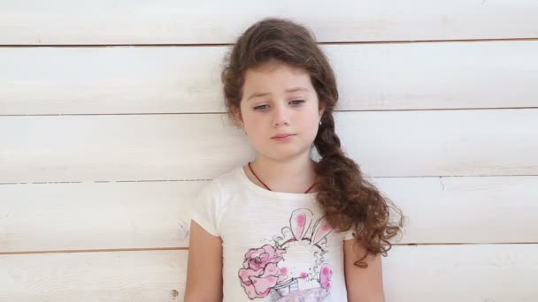 Triste fille debout à un mur blanc — Video