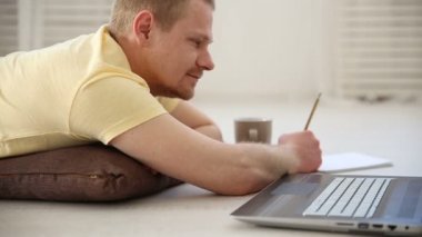 evde bir dizüstü bilgisayar arkasında katta çalışan serbest erkek