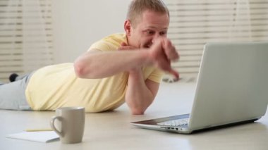 memnun freelancer adam tartışma için yerde bir dizüstü bilgisayarda görüntülü sohbet arkadaşları