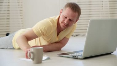 evde bir dizüstü bilgisayar arkasında katta çalışan serbest erkek