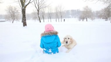 aşk için pets - kız parkta karda bir golden retriever ile dinleniyor