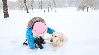 aşk için pets - kız parkta karda bir golden retriever ile dinleniyor