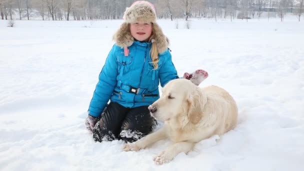愛するペットの女の子は公園で雪の中でのゴールデン ・ リトリーバーと休憩 — ストック動画