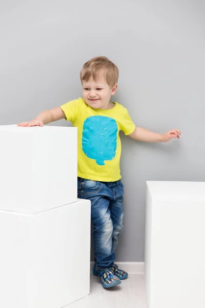 Szczęśliwy chłopiec bawi się białe duże kostki — Zdjęcie stockowe