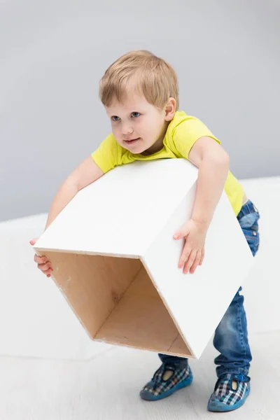 Pequeño niño feliz jugando con cubos grandes blancos — Foto de Stock
