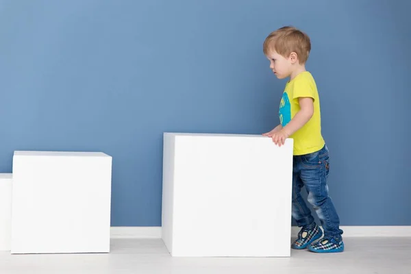 Šťastný chlapec hraje s bílým velké kostky — Stock fotografie