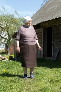 Yaşlı bir kadının yakın köyün harap binalar standları.