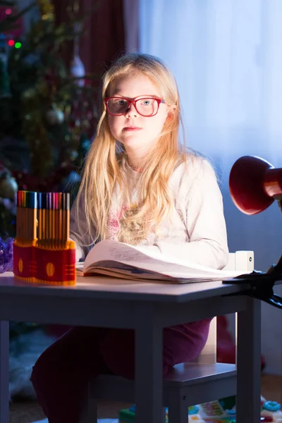 Het meisje doet huiswerk aan de tafel — Stockfoto