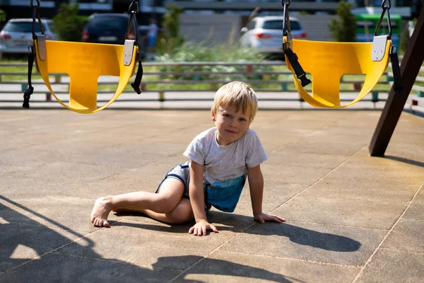 Life of children in a modern city - little boy is having fun on the playground near the house — Stock Photo, Image