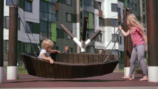 La vida de los niños en la ciudad moderna - la muchacha se divierte en el parque infantil cerca de la casa — Vídeos de Stock