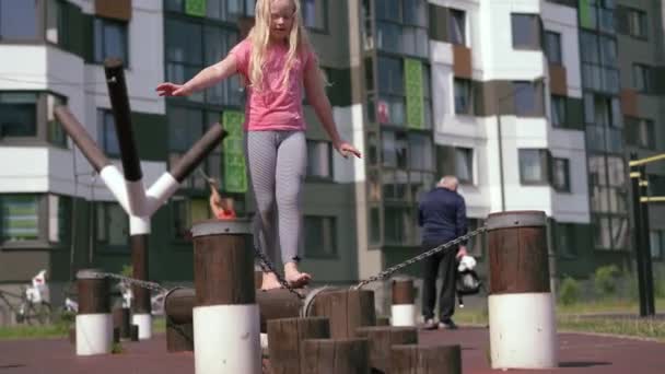 A gyermekek egy modern város - élet a lány jól érzik magukat a játszótéren, a ház közelében — Stock videók