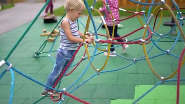 La vida de los niños en una ciudad moderna - niño se divierte en el patio de recreo cerca de la casa — Vídeos de Stock