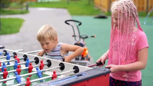 Moderne leven in een grote stad - kinderen spelen tabel hockey op straat — Stockvideo
