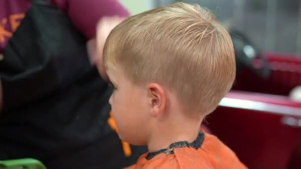 Haarschnitt eines kleinen Jungen im Kinderfriseursalon — Stockvideo