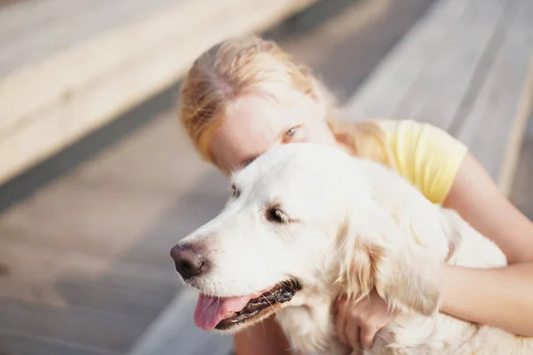 Amor por las mascotas - una joven rubia descansando con su perro en la calle —  Fotos de Stock