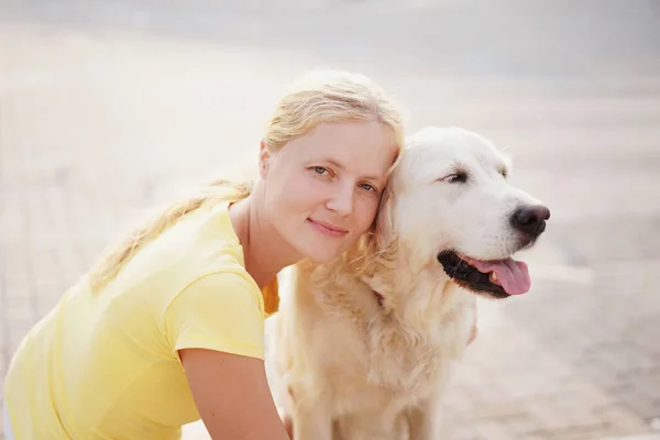 Miłość do zwierząt - młoda kobieta blonde odpoczynku z psem na ulicy — Zdjęcie stockowe