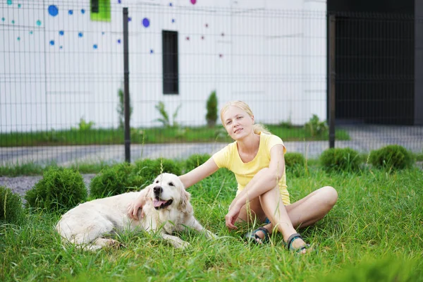 Miłość do zwierząt - młoda kobieta blonde odpoczynku z psem na trawie — Zdjęcie stockowe