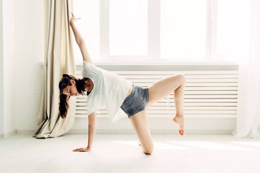 Genç güzel kız ısınma çağdaş evde yapıyor