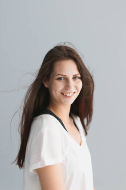 Stüdyoda gri arka planda güzel bir kızın portresi.