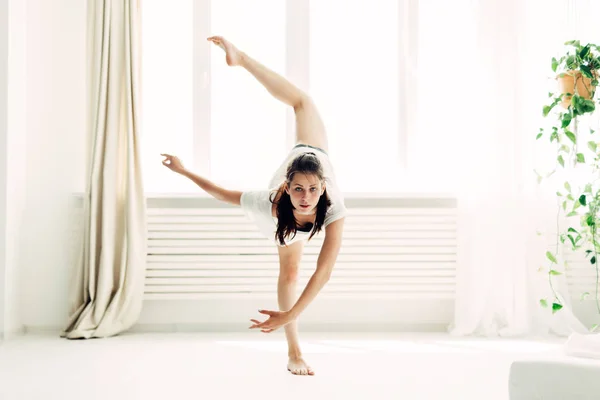 Jovem menina bonita fazendo aquecimento contemporâneo em casa — Fotografia de Stock