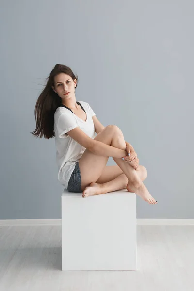 Retrato de una hermosa chica en el estudio sobre un fondo gris — Foto de Stock