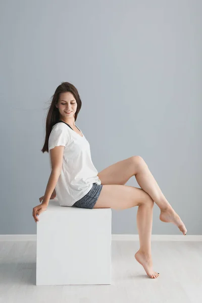 Porträtt av en vacker flicka i studion på en grå bakgrund — Stockfoto