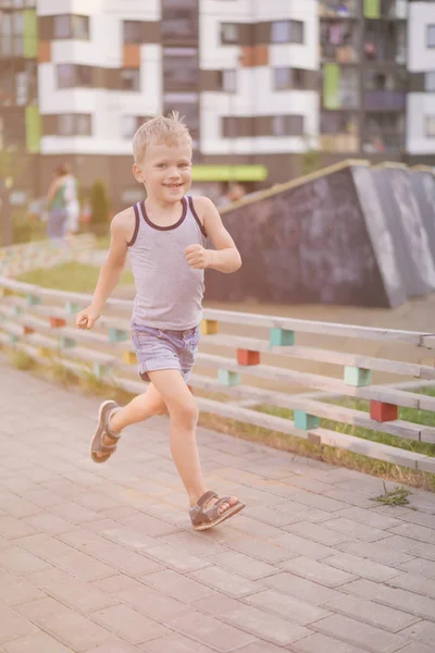 Život dětí v moderním městě - chlapeček se baví na hřišti nedaleko domu — Stock fotografie