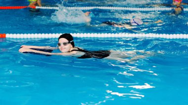 yüzme dersleri için çocuk havuzu - güzel tenli kız suda yüzüyor.